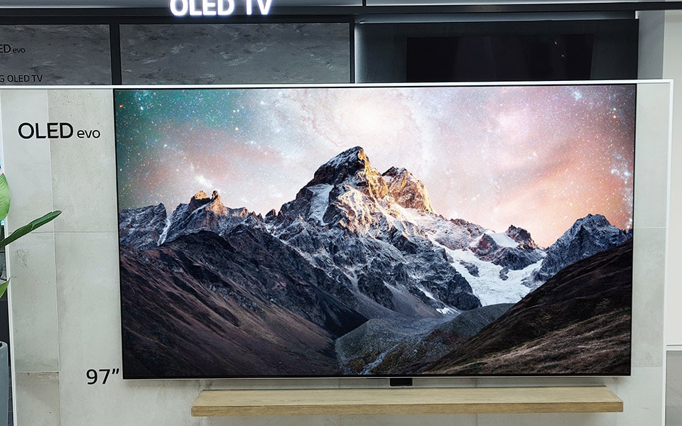 An image of a man and a woman watching LG CX 48 inch TV while sitting on the sofa.